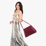 Orchid Large | Model carrying large triangular shoulder bag with antiqued brass finished hardware