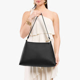 Pebbled--black Large | Model holding large triangular shoulder bag with antiqued brass finished hardware