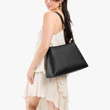 Pebbled--black Large | Model carrying large triangular shoulder bag with antiqued brass finished hardware