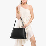 Pebbled--black Large | Model carrying large triangular shoulder bag with antiqued brass finished hardware