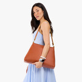 Sienna Large | Model carrying large triangular shoulder bag with antiqued brass finished hardware