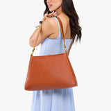 Sienna Large | Model carrying large triangular shoulder bag with antiqued brass finished hardware