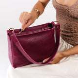 Orchid Small | Model holding triangular shoulder bag with antiqued brass finished hardware
