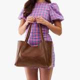 Asheville Large | Woman holding a wide tote with leather straps and snap closure