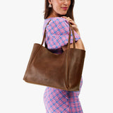 Asheville Large | Woman holding a wide tote with leather straps and snap closure