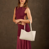 Pebbled Bone Medium | Model holding midsize rectangular tote bag