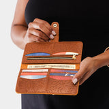 Meadow | Model holding leather wallet with snap open