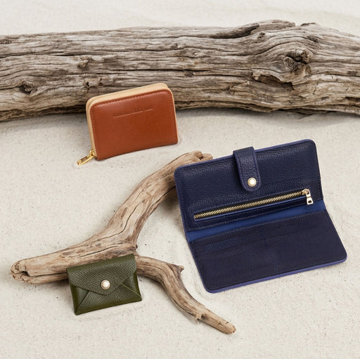 A variety of wallets laying in the sand on a beach. featured image